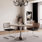 Round dining table with beige rock tabletop and stainless steel legs